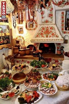 a table filled with lots of food next to a fire place in a room full of decorations