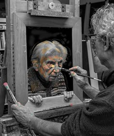 an older woman is painting the face of a man