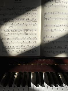 an open book sitting on top of a piano