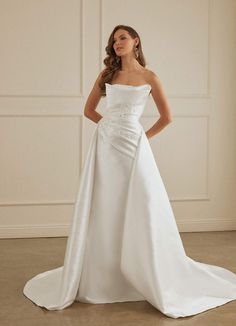 a woman in a white wedding dress posing for the camera with her hands on her hips