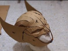 an animal made out of cardboard sitting on the floor