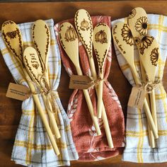 four wooden spoons with designs on them are lined up next to each other and tied together