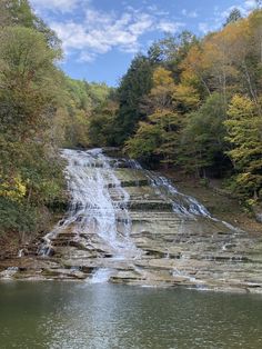 a large waterfall in the middle of a forest