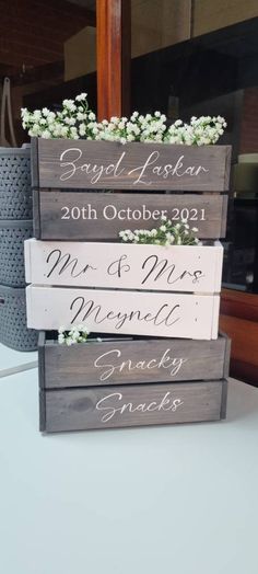 three wooden signs with flowers in them sitting on a white counter top next to a window