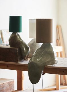 two lamps sitting on top of a wooden table next to a box and lamp shade