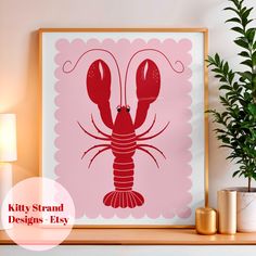 a framed art print of a red lobster on a pink background next to a potted plant