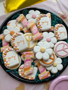 decorated cookies in the shape of letters and numbers on a plate with pink, yellow, and white icing