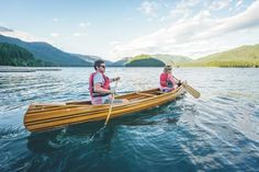 two people in a canoe paddling on the water