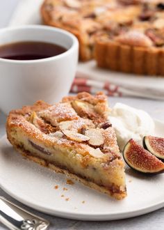 a slice of pie on a plate next to a cup of tea