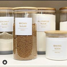 several jars filled with different types of baking ingredients on top of a counter next to each other