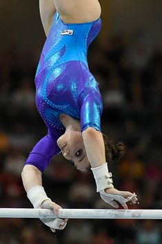 a woman is performing on the balance bars