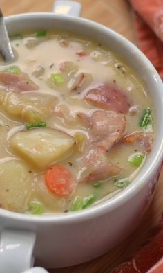 a bowl of soup with meat, potatoes and carrots