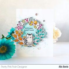 a card with an image of a cat on it and some flowers in the background