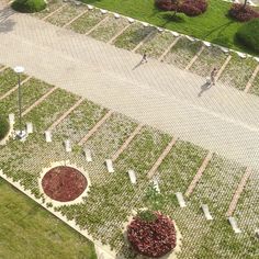 an aerial view of a park with lots of green grass and people walking in the distance