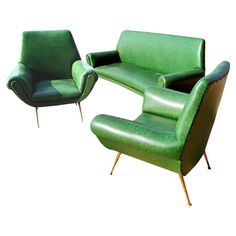 two green leather chairs and a chair with wooden legs, one is shaped like a reclining