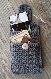 a cell phone in a crocheted pouch on a wooden floor with money sticking out of it