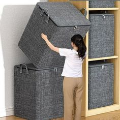 a woman is standing in front of some storage bins that are stacked on top of each other