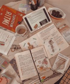 an open book sitting on top of a table next to a cup of coffee and other items