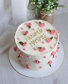 a white cake with pink roses on it