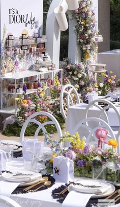 an outdoor event with tables and chairs covered in flowers