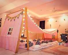 a bed with a canopy and pillows on the floor in a room decorated for christmas