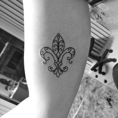 a black and white photo of a woman's arm with a tattoo on it