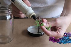 a person is making something out of some kind of plastic bottle with scissors and glue