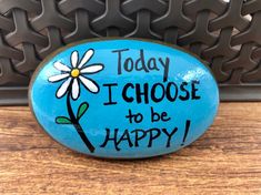 a painted rock that says today i choose to be happy with a flower on it