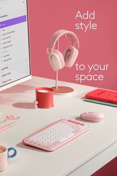 a desktop computer with headphones on it next to a keyboard and mouse in front of a pink wall