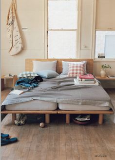 a bed sitting on top of a wooden floor next to a window