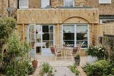 an outdoor patio with chairs and tables in front of a brick building