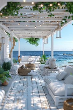 an outdoor living area with white furniture and greenery on the roof over looking the ocean