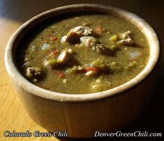 a wooden bowl filled with soup on top of a table