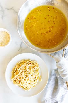 a bowl of soup next to a plate of noodles