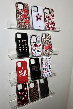 several cell phones are displayed on shelves in a display case with red, white and black designs