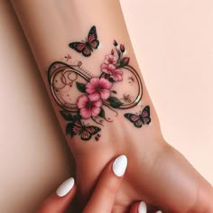 a woman's foot with flowers and butterflies on it, next to her hand