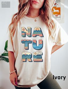 "PRODUCTION TIME: 1-3 days (Usually 2 days) SHIPPING TIME: 2-5 days (Usually 3 days) 👕PRODUCT DESCRIPTION👕  Looking for a stylish and comfortable tee that celebrates the beauty of nature? Look no further than our Nature Tee, featuring the word \"NATURE\" spelled out in a retro-inspired font that's sure to turn heads. Made with high-quality Comfort Colors 1717 material, this vintage-inspired t-shirt is perfect for nature lovers who want to show off their love of the great outdoors. The unisex d Botanical Tshirt, Lover Clothes, Nature Tees, Nature Shirts, Hippie Style, Unisex Design, Tee Design, Retro Inspired, Cute Shirts