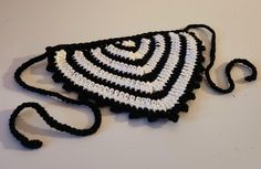 a crocheted black and white purse on a table