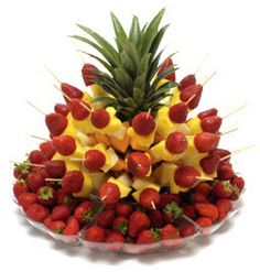 a pineapple and strawberries arrangement in a bowl