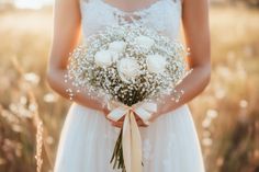 a woman in a white dress holding a bouquet of flowers