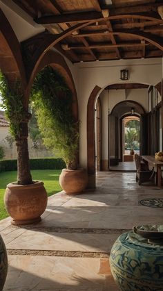 an outdoor dining area with potted plants and large vases