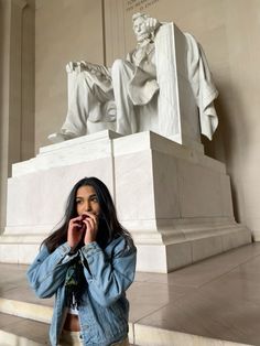 a woman standing in front of the lincoln memorial talking on her cell phone