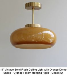 an orange light hanging from a ceiling fixture