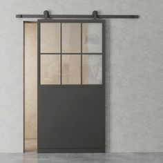 an empty room with a gray door and glass windows