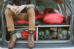 a man sitting in the back of a van filled with clothes