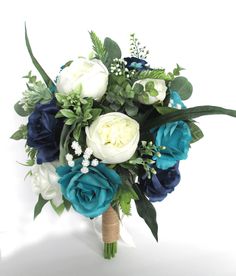 a bridal bouquet with blue, white and green flowers on a wooden stick in front of a white background