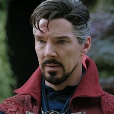 a close up of a person with a goatee and beard wearing a red jacket