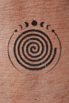 an abstract tattoo design on the back of someone's arm with circles and stars