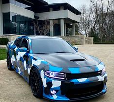 a blue camo car parked in front of a house