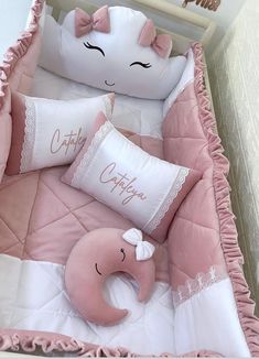 a pink and white baby crib with two pillows on the bottom one has a pillow that says, coty often